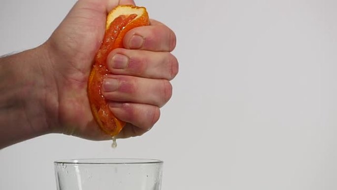 男性用手榨新鲜橙汁。用手榨橙子