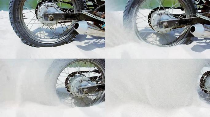 越野摩托车的轮子开始旋转，扬起地面和沙子