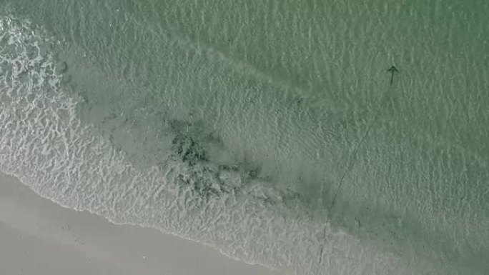 空中: 波浪海岸海滩，锚定在清澈的浅水区