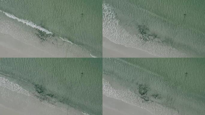 空中: 波浪海岸海滩，锚定在清澈的浅水区
