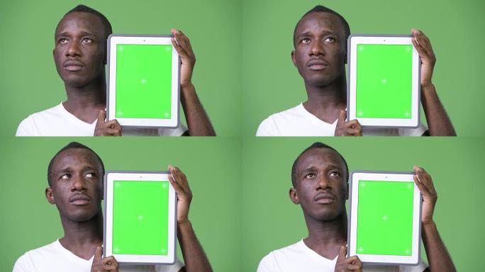 年轻的非洲男子在展示数字平板电脑时思考