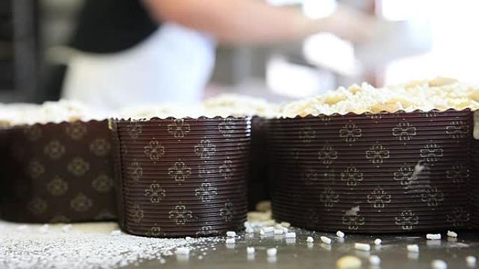 糕点厨师用手将糖粉撒在面团上，用于复活节蛋糕鸽子