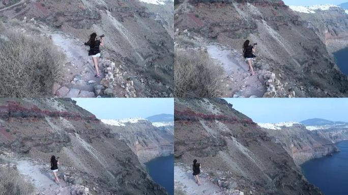 女孩喜欢徒步旅行到希腊圣托里尼岛伊莫洛维格利的斯卡罗斯岩