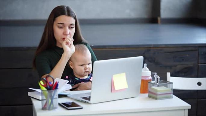 勤劳的女人带着孩子在办公室做笔记。