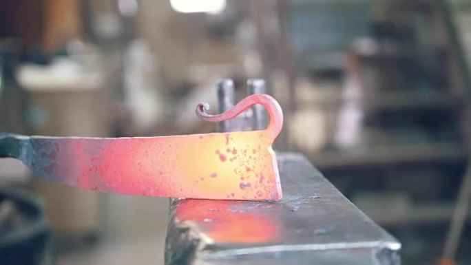 铁匠用铁锤在锻造炉中塑造热钢