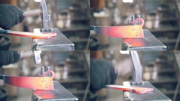 铁匠用铁锤在锻造炉中塑造热钢