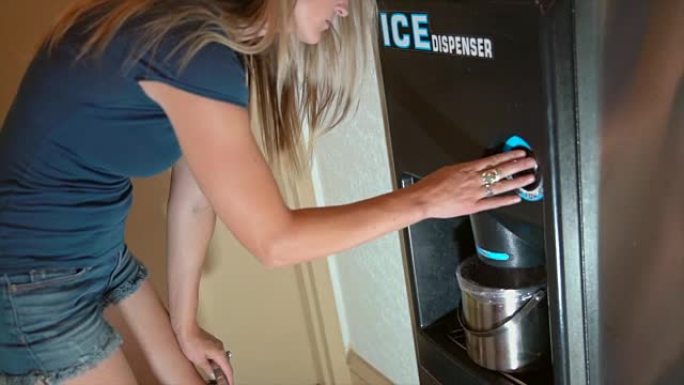 女人从酒店制冰机上拿冰