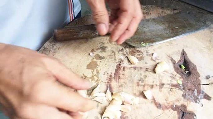 在亚洲厨房的木制砧板上剥蒜瓣