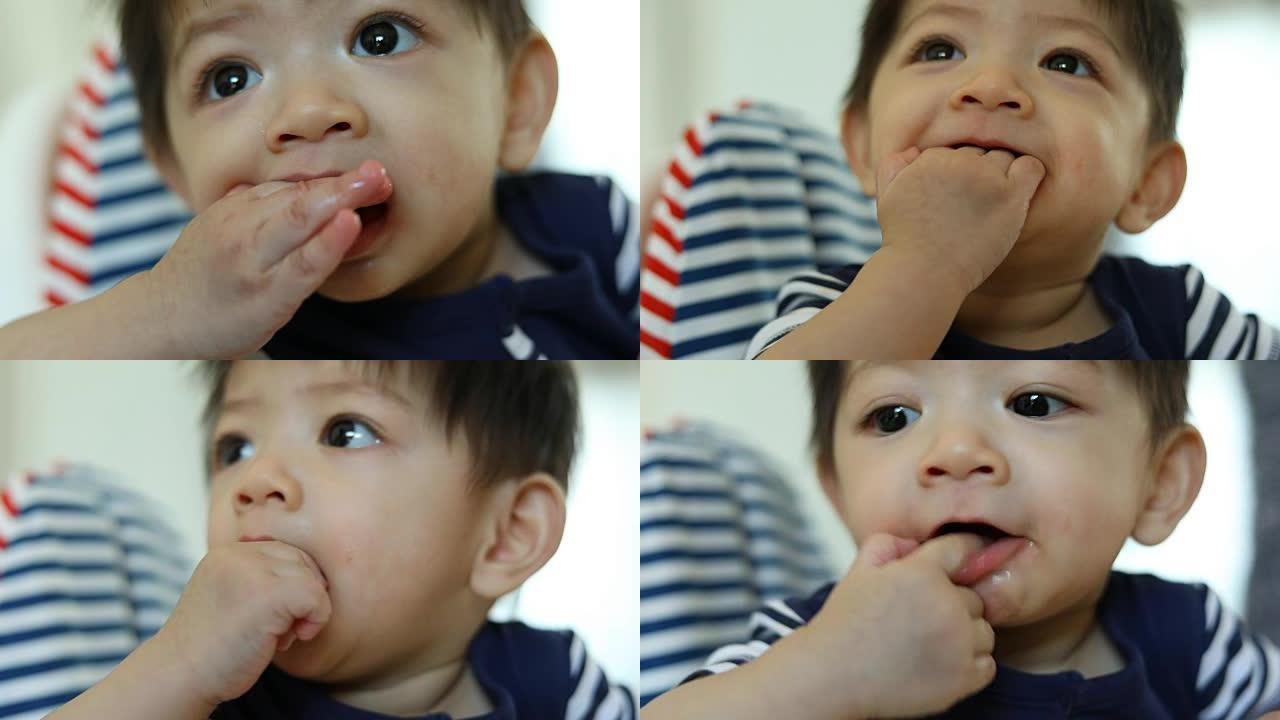 可爱的孩子宝宝用手指在嘴里发痒的口香糖，慢动作场景