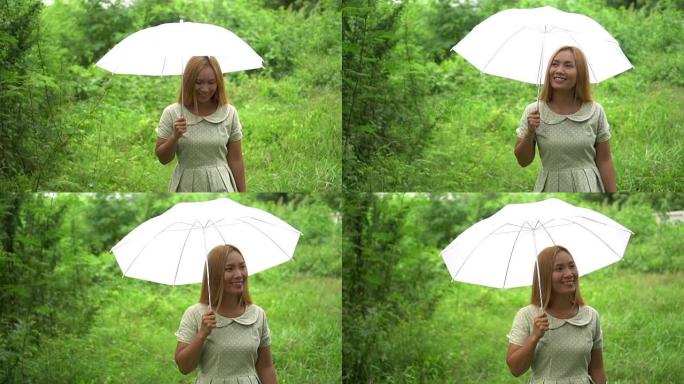 女人在雨下走路手拿着白伞
