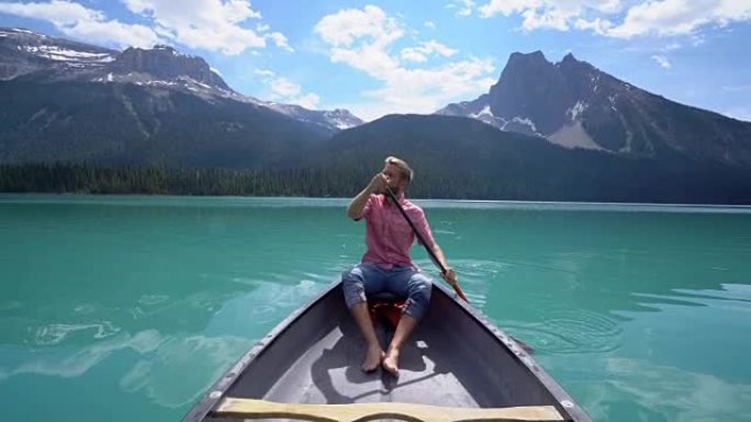 年轻人在令人惊叹的原始翡翠湖上划独木舟