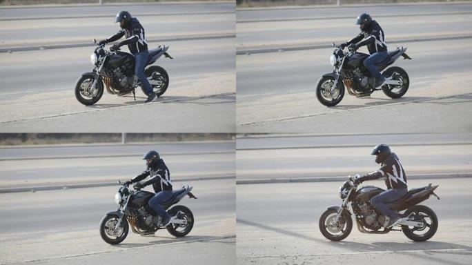 街上戴着黑色头盔的年轻迷人摩托车手。男子摩托车手