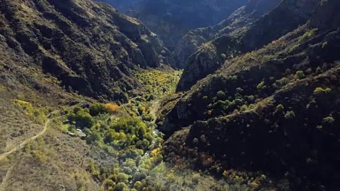 空中无人机拍摄了山脉之间的森林ravibe，河流和下面的废弃修道院