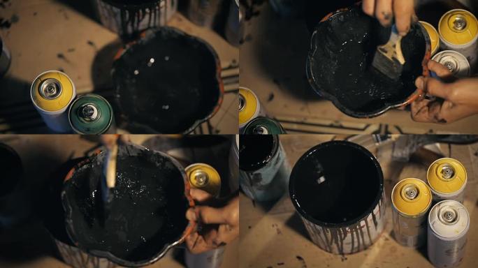画家用黑色油漆将溶剂倒入碗中，并用刷子将其混合
