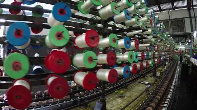 妇女在曼德勒缅甸的织物工厂的线轴上制作棉线
