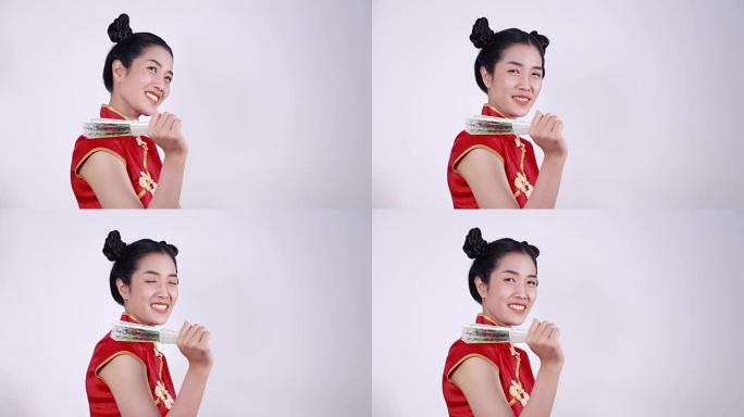 女人穿着中国旗袍，抱着中国风扇