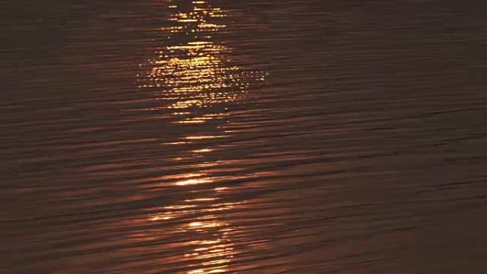 波浪水，日落时金色暖色调。可用于背景。