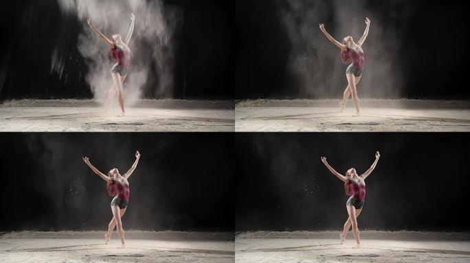 美丽的芭蕾舞演员在演播室与粉雪跳舞。慢动作