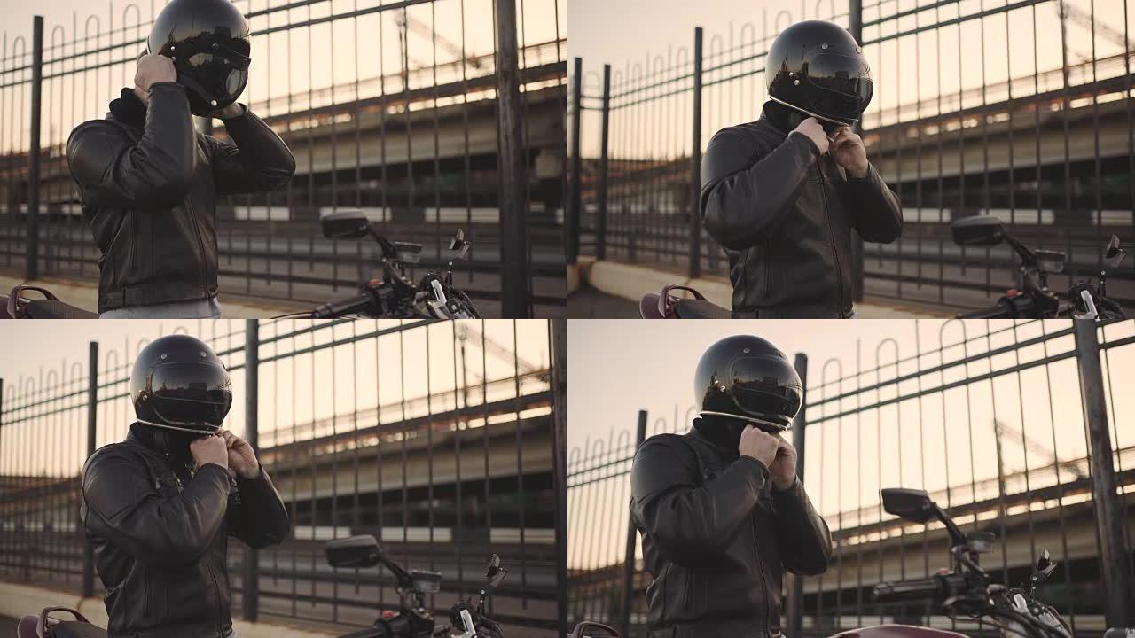年轻有魅力的摩托车手，戴着头盔和定制摩托车在街上