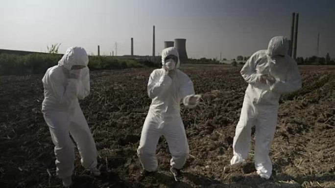 工程师工人穿着保护性的危险品衣服，被发电厂附近坠落的核废料所陶醉