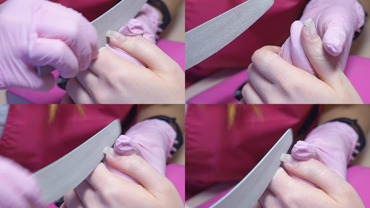慢动作。修指甲。修指甲大师用塑料指甲锉将指甲涂满。无盖天然指甲。高清