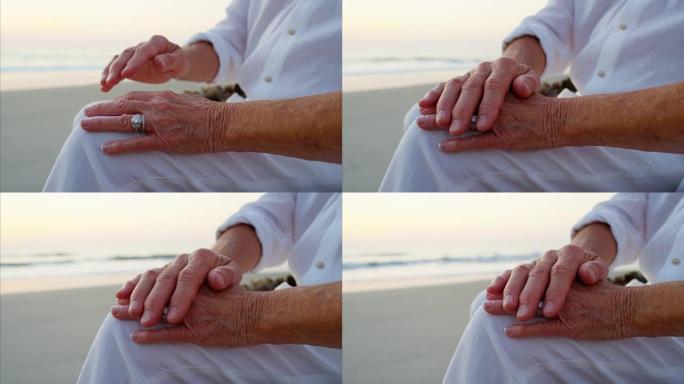 在日落沙滩上牵着手相爱的白人老人