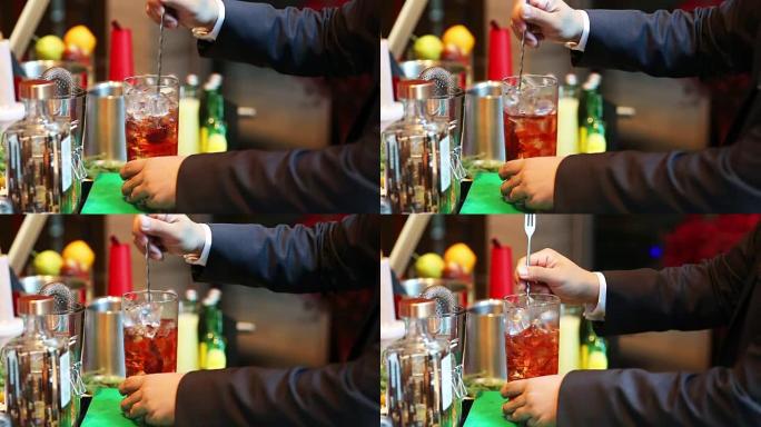 调酒师在酒吧将鸡尾酒与酒杯混合，将酒保手倒入酒杯中