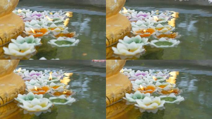 镀金佛像周围漂浮着莲花形状的多色蜡蜡烛