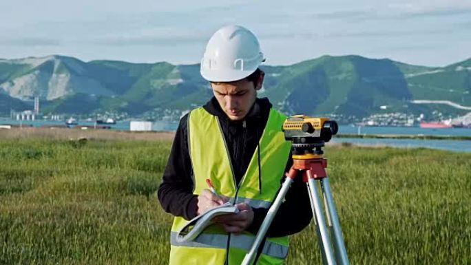 测量员工程师正在施工现场测量水平。大地测量仪确保在进行大型建筑项目之前进行精确的测量。景观设计的概念