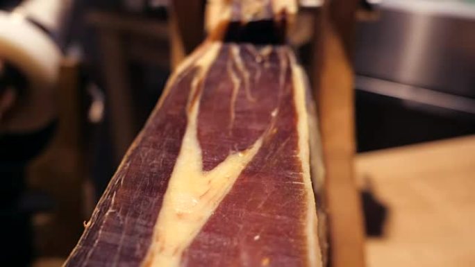 Jamon serrano。市场上的传统西班牙火腿关闭。餐桌上的猪腿火腿。餐厅内部的美味肉。整个ja