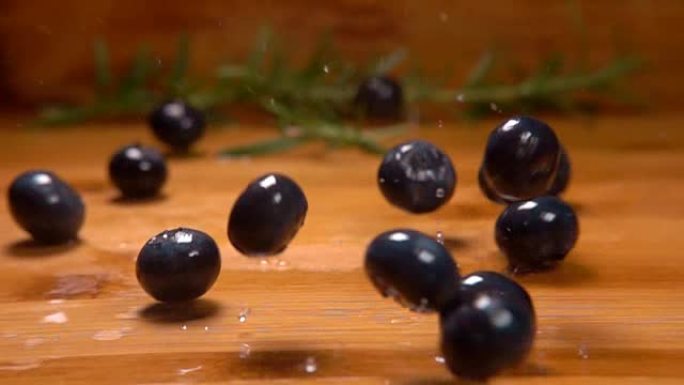 湿蓝莓落在木桌上滚动
