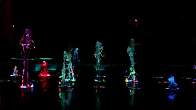 五颜六色的自来水厂喷泉在黑暗的夜晚跳舞