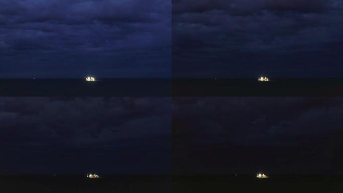延时。海洋和暴风云中的夜晚，远处的渔船。