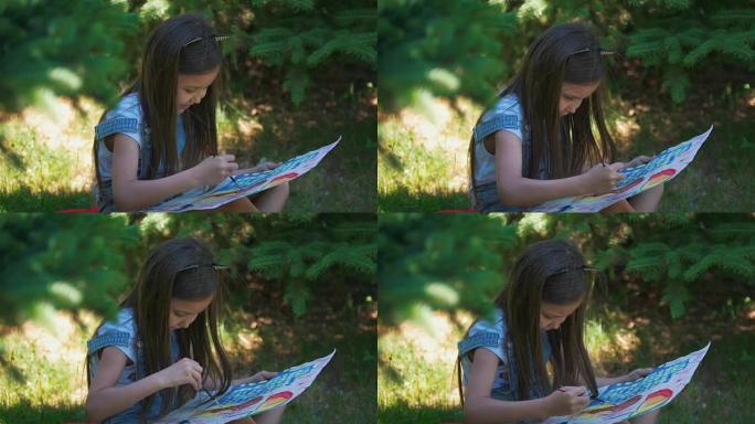可爱的女孩在夏季公园的草地上用水粉画明亮的照片