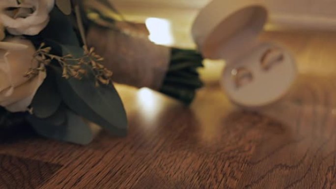 盒子里的结婚戒指靠近地板上美丽的结婚花束