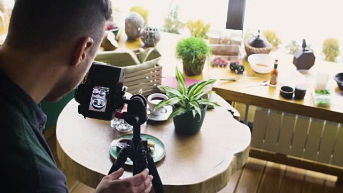使用数码相机拍摄人的三脚架并在木桌上制作食物照片