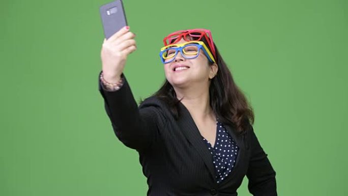 成熟美丽的亚洲女商人戴着许多眼镜时使用手机作为有趣的概念