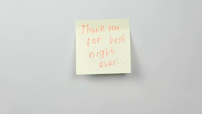 特写女人的手贴黄色贴纸纸，上面写着 “谢谢你有史以来最好的夜晚”。