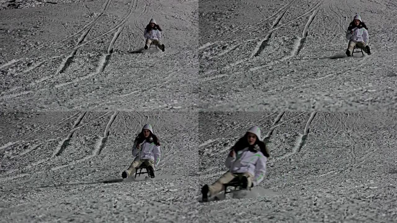 孩子在冬天晚上拉雪橇，女孩在雪地上奔跑和摔倒。UHD变焦股票视频