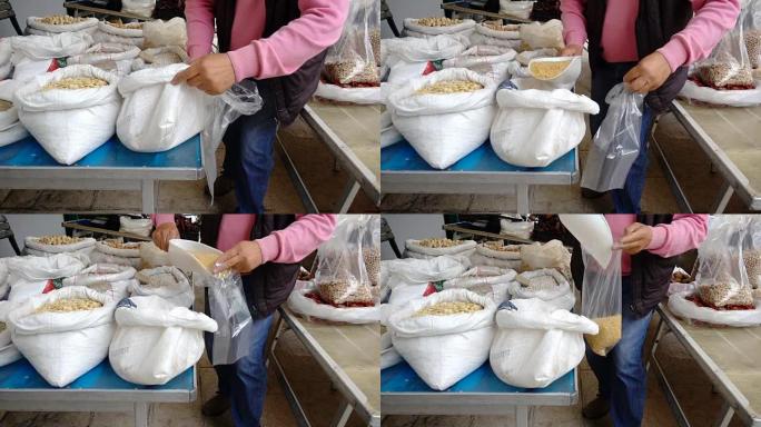 农民将新鲜的鹰嘴豆放在市场上的袋子里