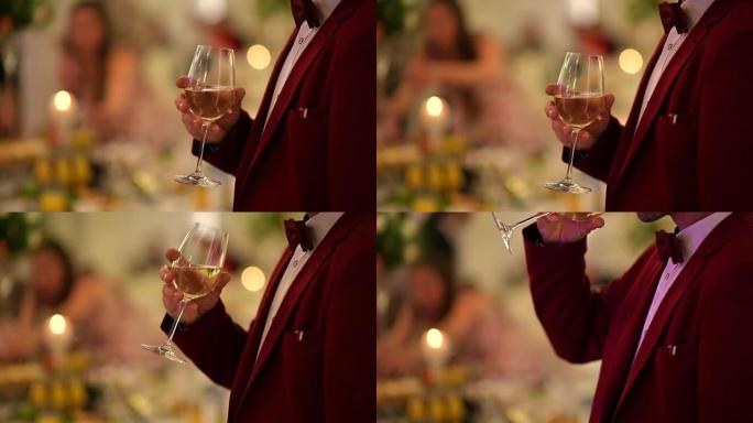 穿着勃艮第燕尾服的绅士，手里拿着一杯白葡萄酒。派对主题。