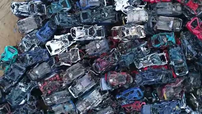 碾碎腐蚀的旧车堆放在废品场里。