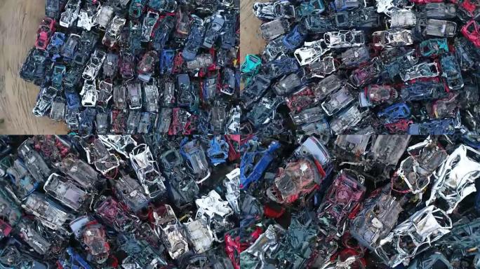 碾碎腐蚀的旧车堆放在废品场里。