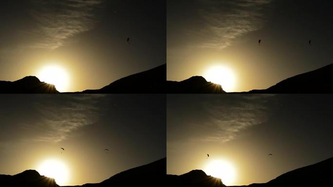 滑翔伞在山上日落时滑翔伞飞行，背光