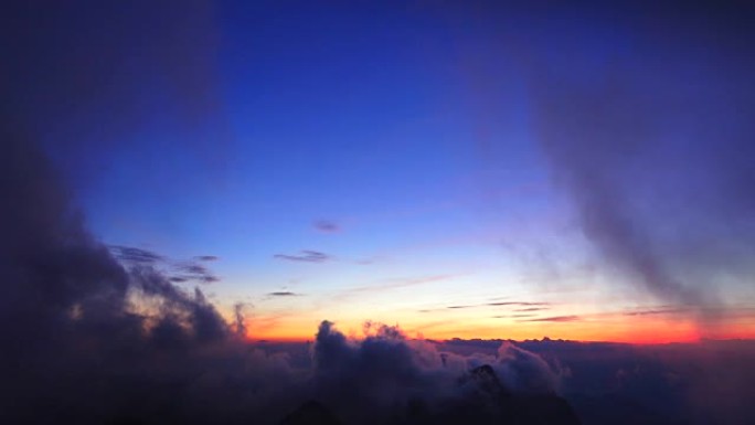 Landscape of rolling clouds over mountain.