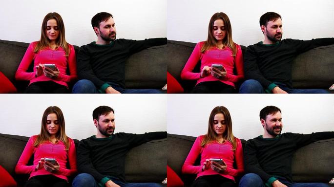 男人和女人坐在沙发上，女人看智能手机，男人转身离开
