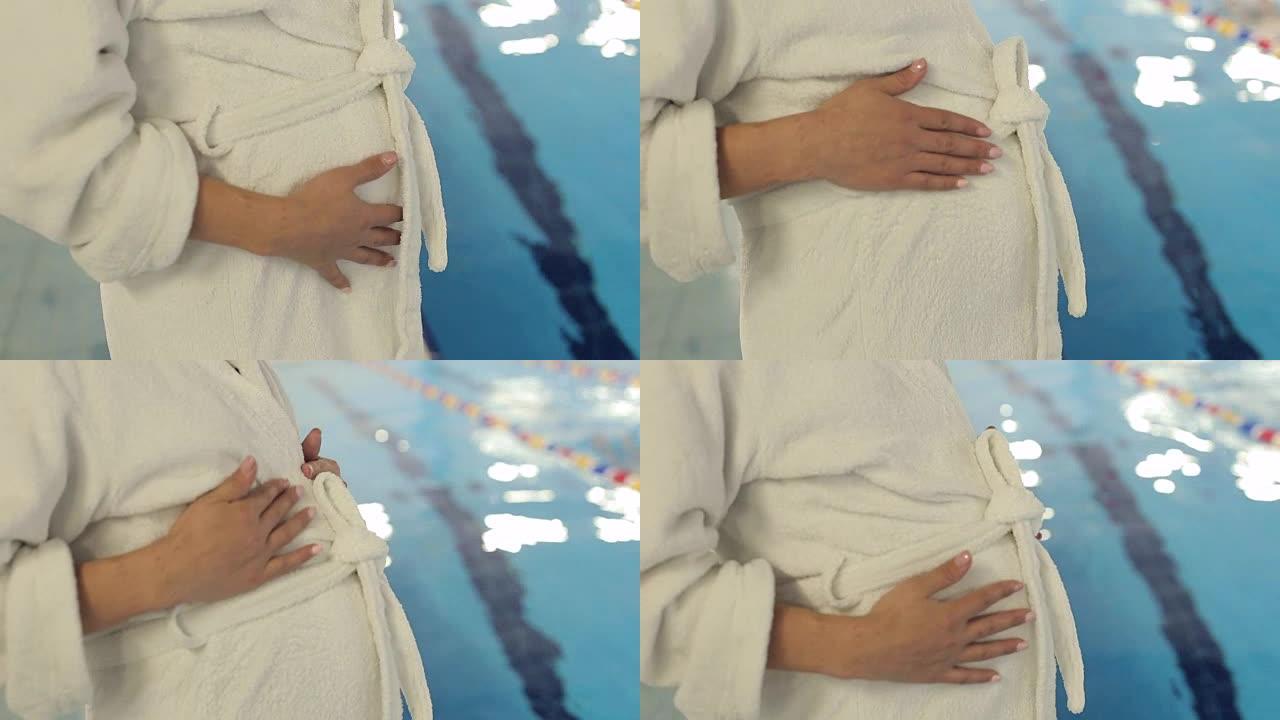 穿着白色长袍的孕妇腹部特写