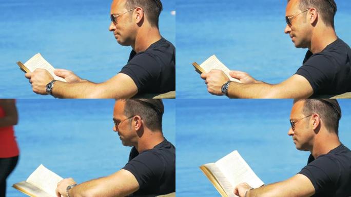 一个男人在晴朗的天气里在长凳上发冷，翻阅一本书