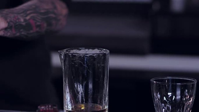 特写一名男性调酒师在酒吧准备酒精混合饮料的移动镜头
