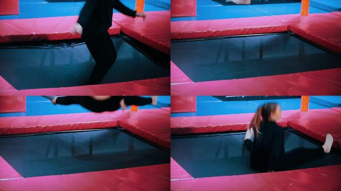 年轻的杂技演员表演杂技技巧-在蹦床大厅跳跃，慢动作
